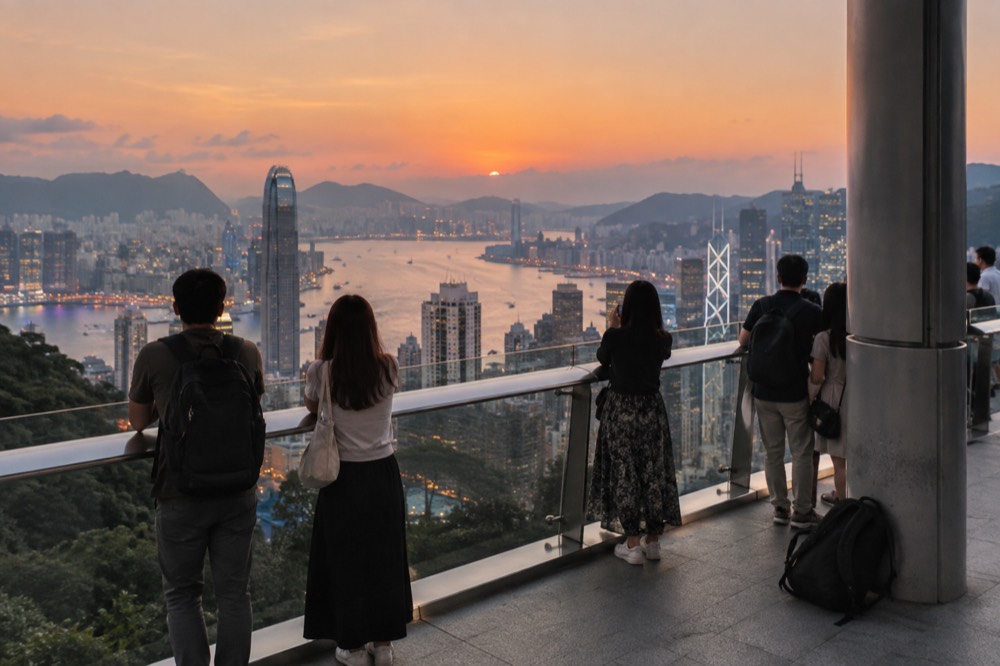 The Sky Terrace 428 observation deck on the Peak Tower roof at dusk, with visitors looking out over Victoria Harbour