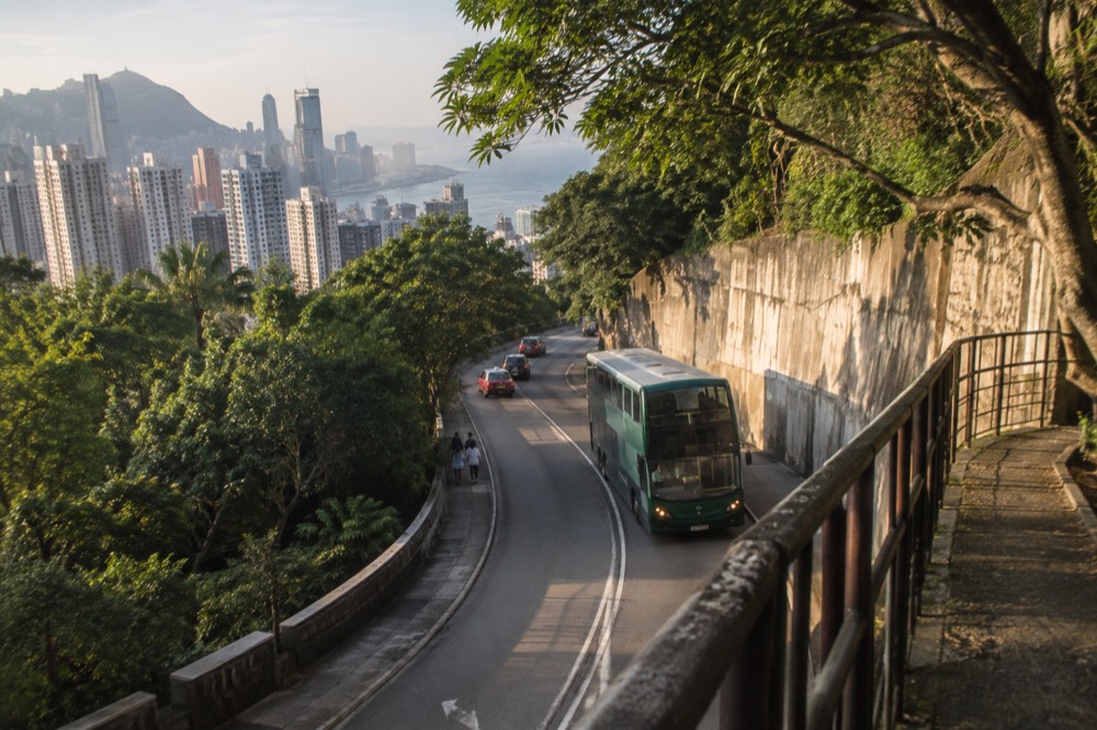 Green Citybus double decker on the winding road below Victoria Peak