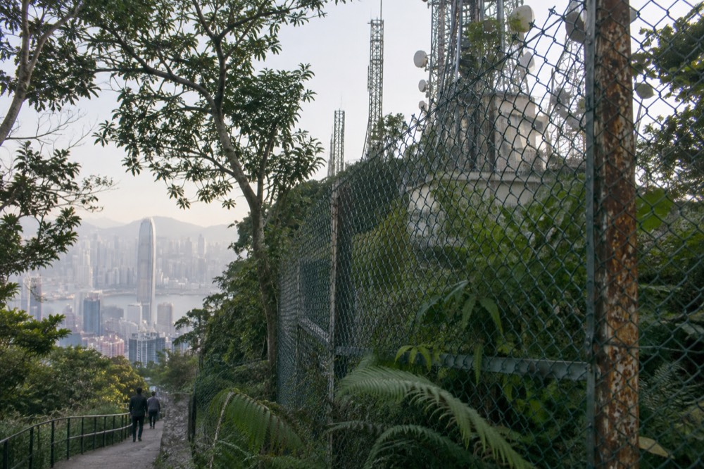 Fenced radio installation on the closed summit of Victoria Peak seen from a nearby path