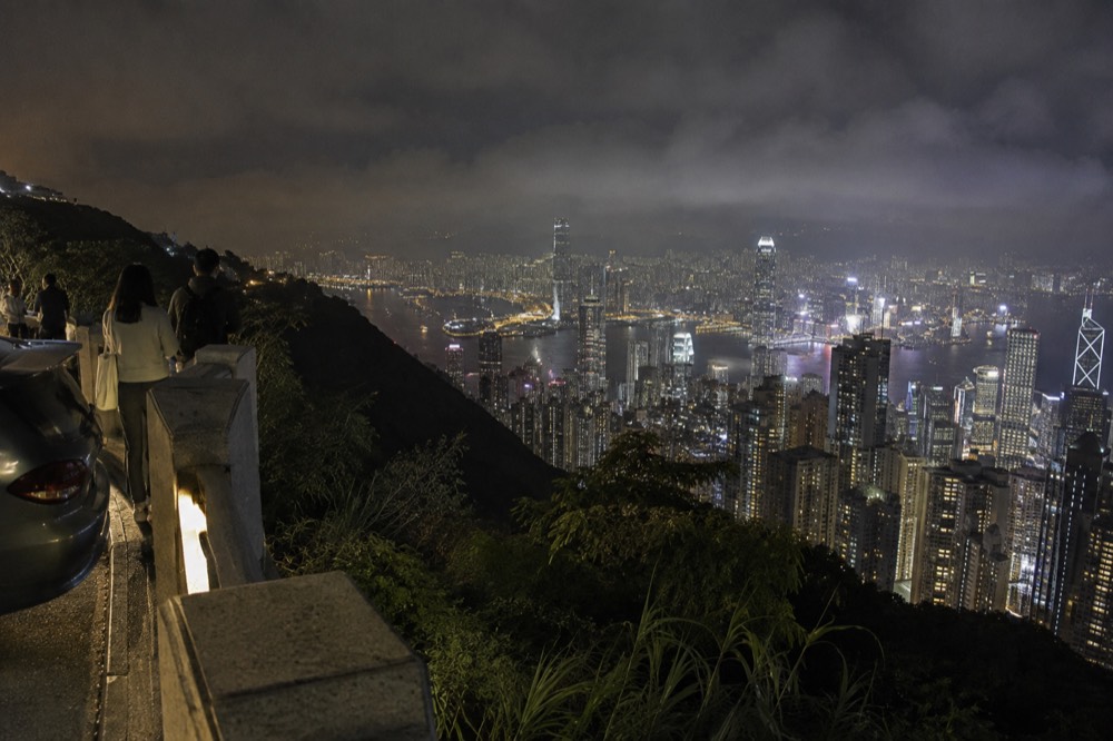 City lights spread across a harbour below dark hills at night