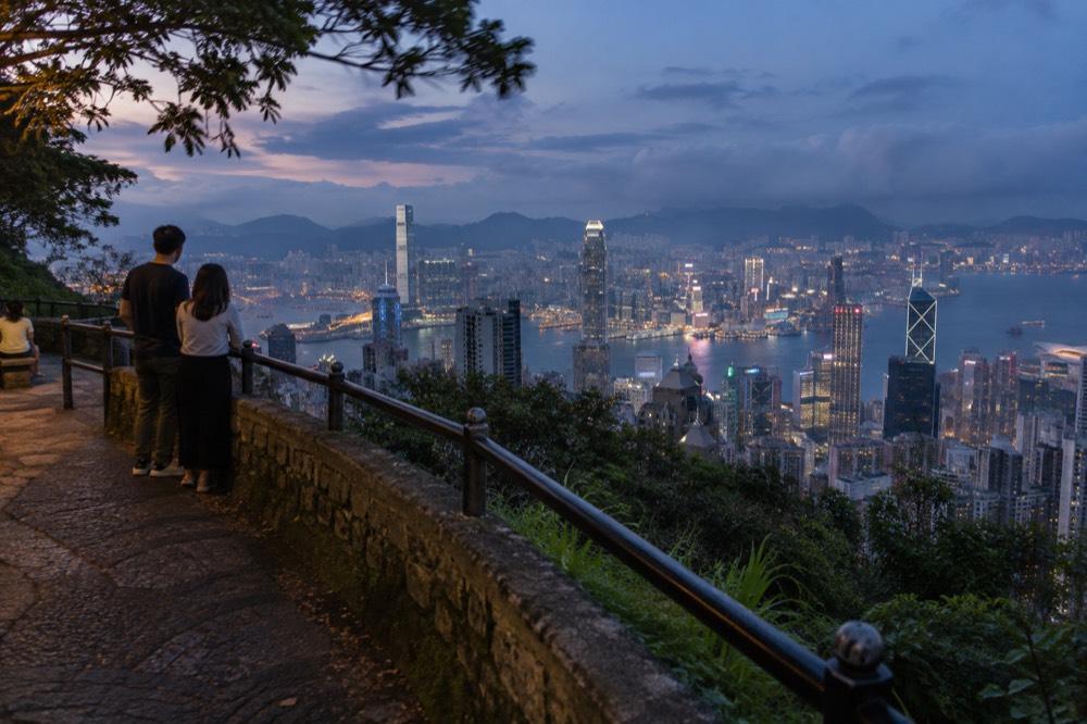 Night panorama of harbour lights and skyscrapers from a free roadside viewpoint