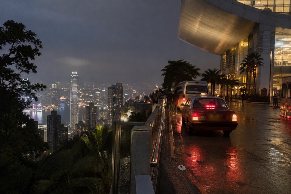 Bus and minibus stop at night with the lit city below the hill