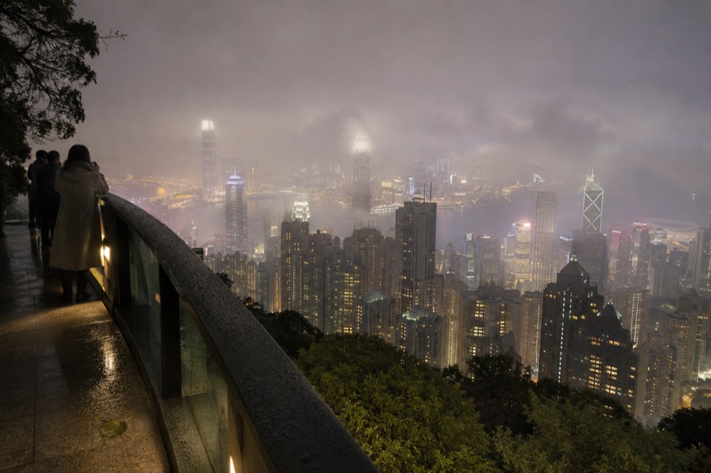 City skyline at night with thin cloud passing over the illuminated towers