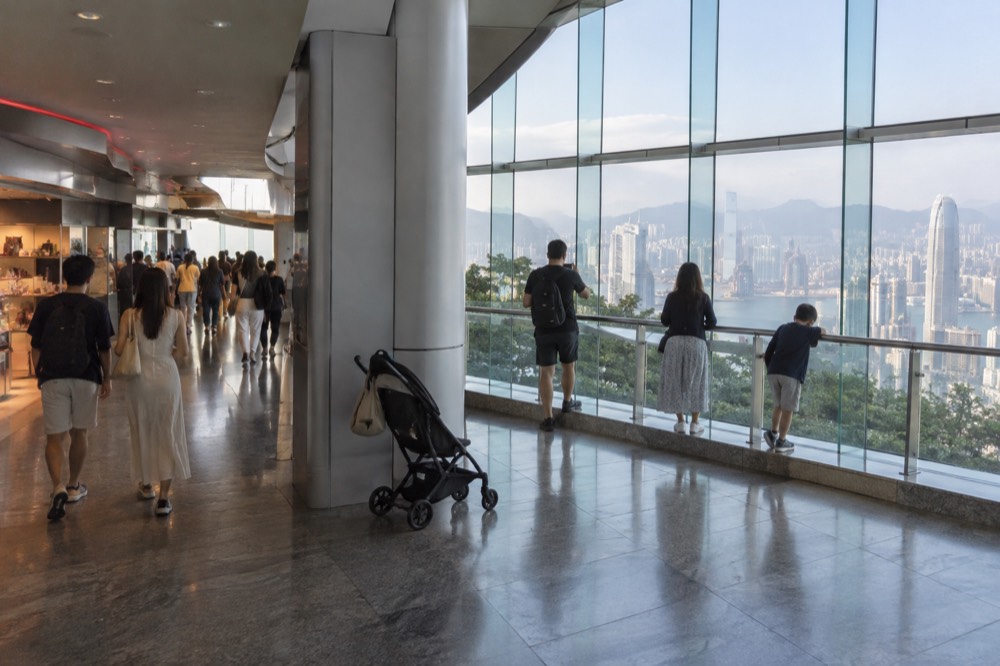 The interior of The Peak Tower with the tram terminus concourse and visitors walking through