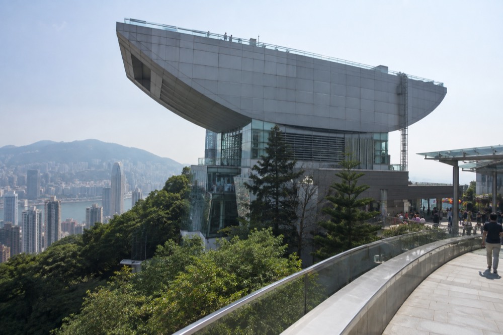 The distinctive curved wok-shaped roofline of The Peak Tower against the sky