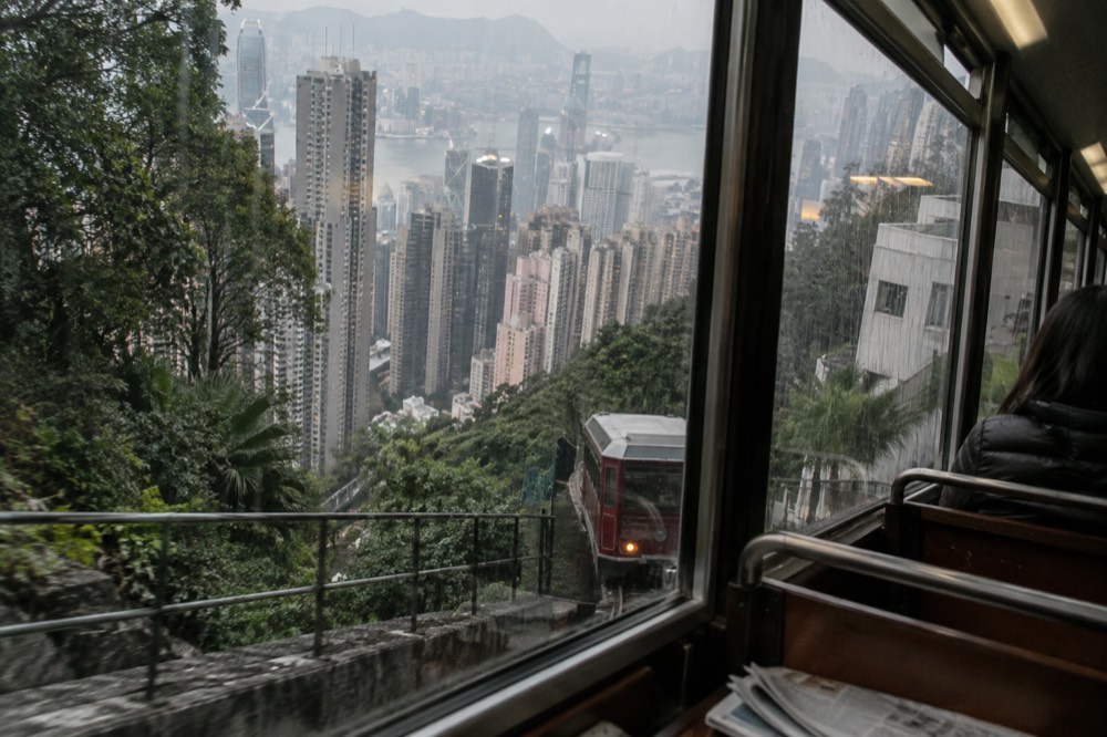 Tall apartment buildings appearing tilted against the sky from inside a funicular car